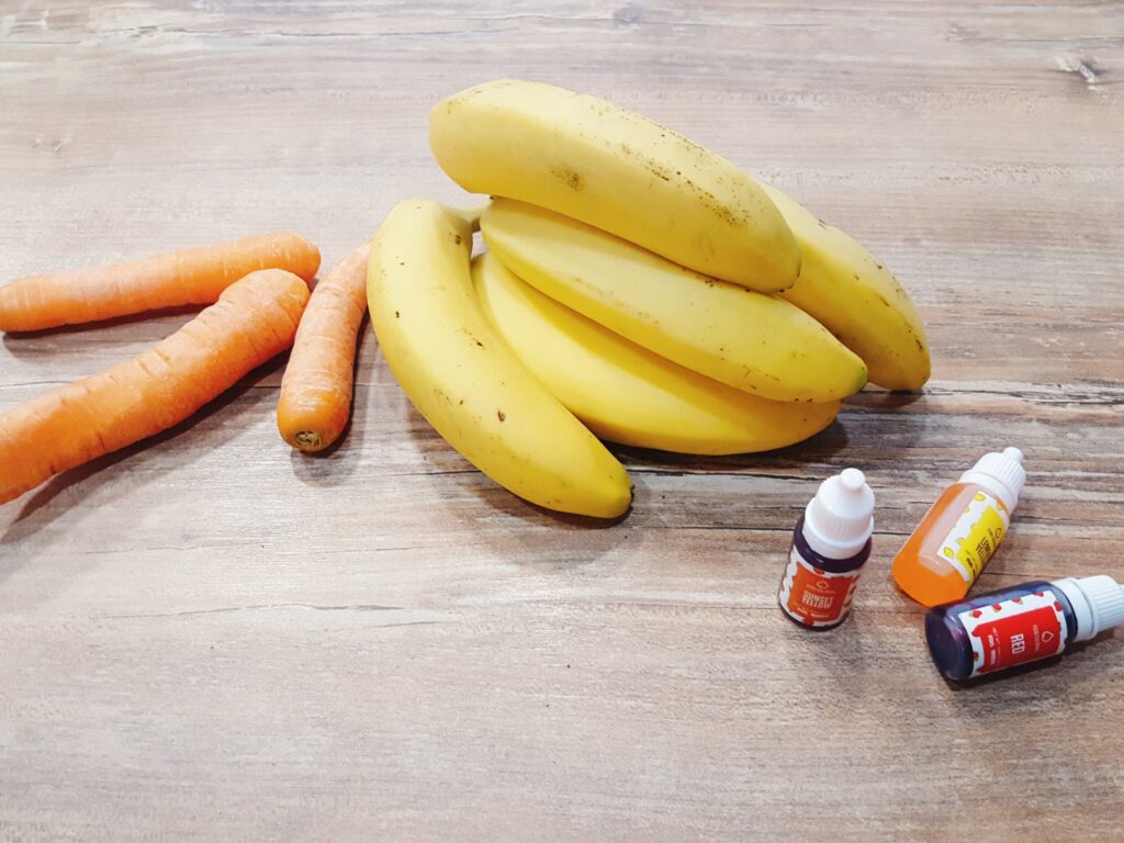 Karotten, Bananen und Lebensmittelfarbe für den Carrot-Banana-Cake